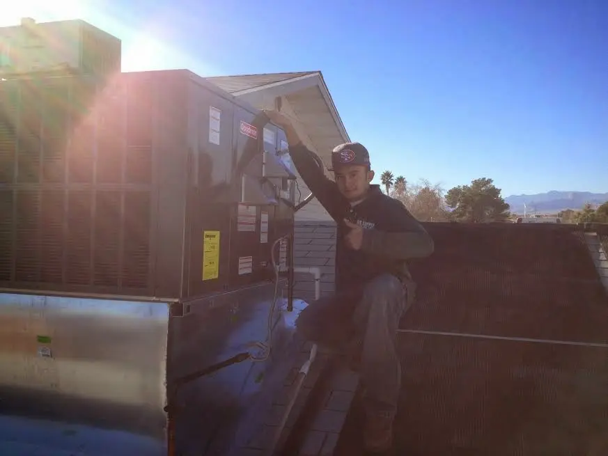 HVAC technician performing Boiler Repair on a rooftop unit in Dakota Dunes